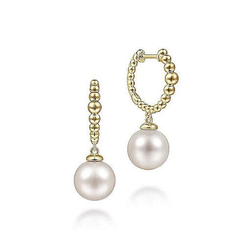 A pair of pearl hoop earrings in yellow gold.